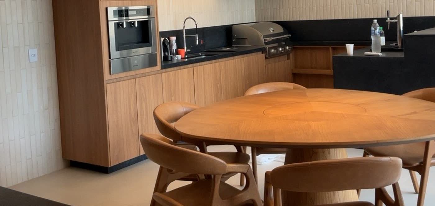 Espaço gourmet com marcenaria e mesa de madeira