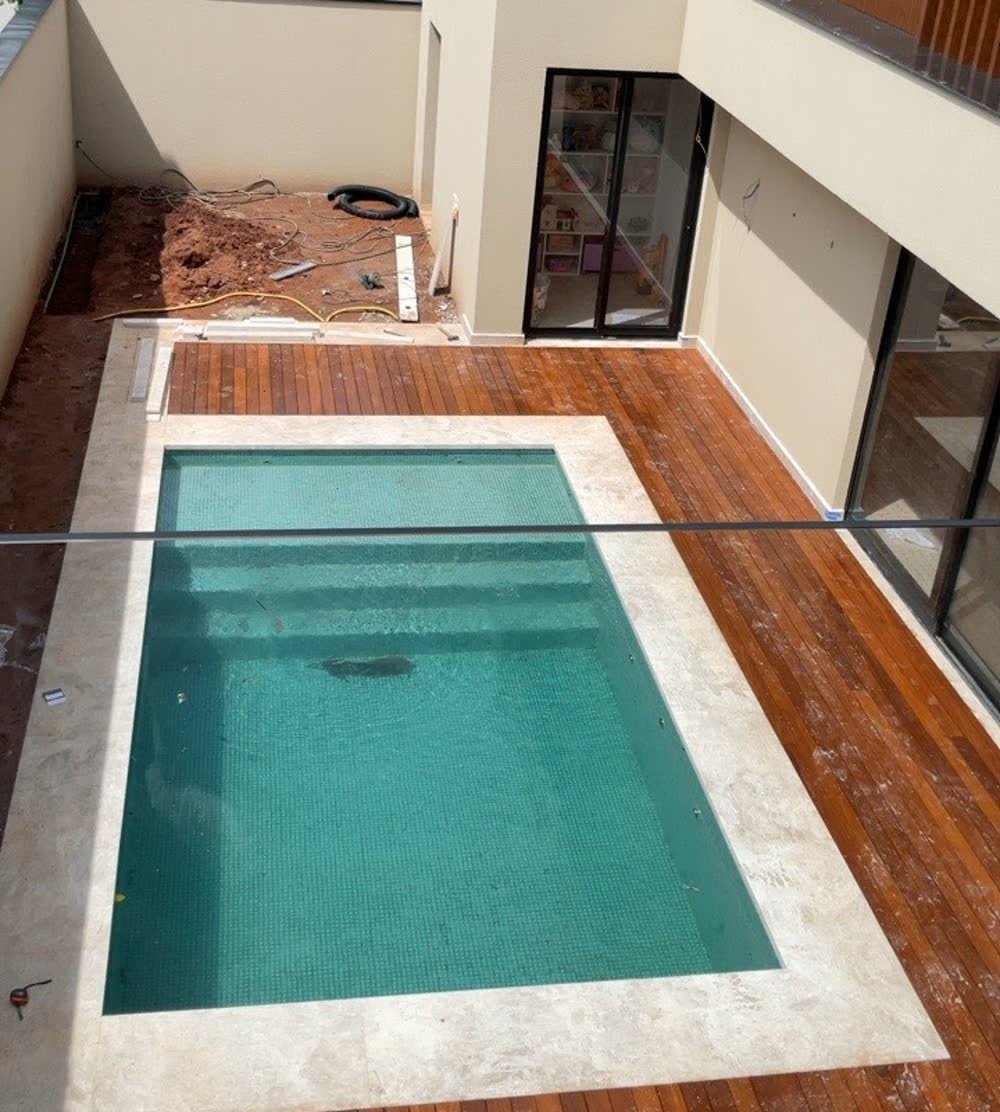 Piscina e deck de madeira na área externa da residência