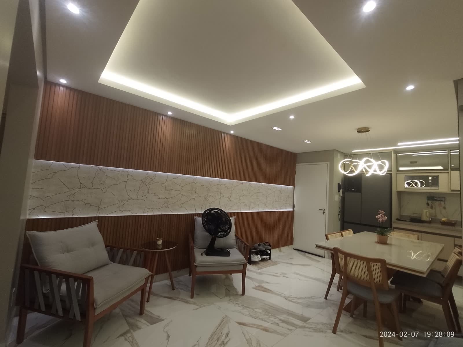 Sala e jantar do apartamento de Stefany e Danilo com iluminação e mobiliário finalizados