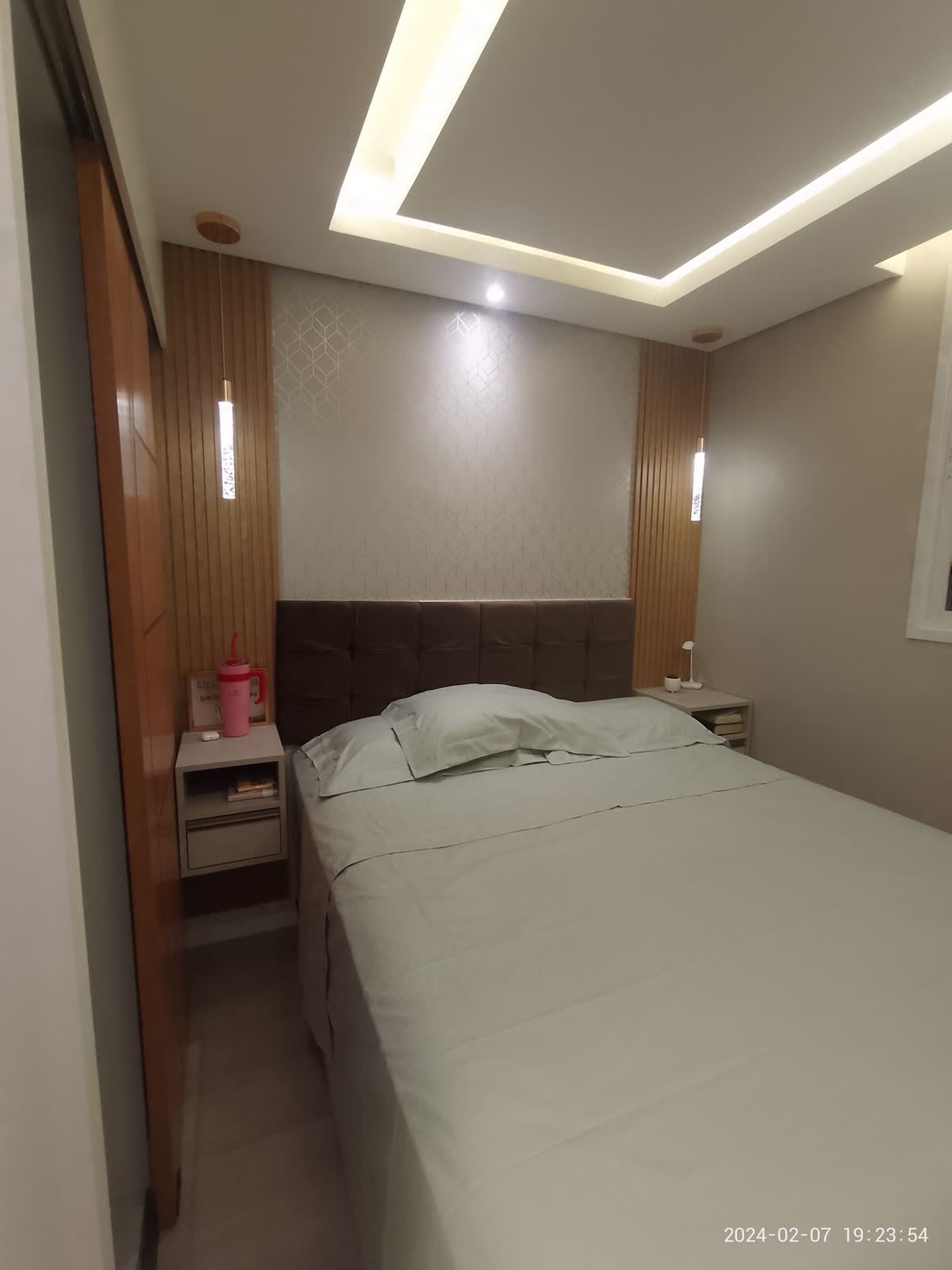 Quarto de casal com cabeceira, marcenaria e iluminação embutida